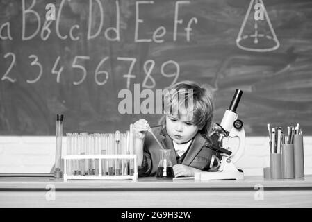 Technologie- und Wissenschaftskonzept. Kind studiert Biologie und Chemie in der Schule. Schulbildung. Erforschen Sie biologische Moleküle. Kleinkind Genie Baby. Junge Stockfoto