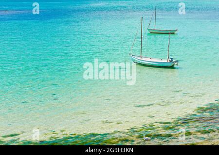 Zwei weiße Fischerboote in der Bucht in der Nähe des Le Hocq Tower am Südufer von Jersey, Channel Islands, Großbritannien, an einem sonnigen Sommertag. Stockfoto