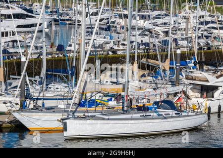Yachten und Motorboote neben dem Yachthafen im Hafen für Kreuzfahrten von Seglern und Motorbooten in lymington, New Forest hampshire. Stockfoto