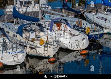 Yachten und Motorboote neben dem Yachthafen im Hafen für Kreuzfahrten von Seglern und Motorbooten in lymington, New Forest hampshire. Stockfoto