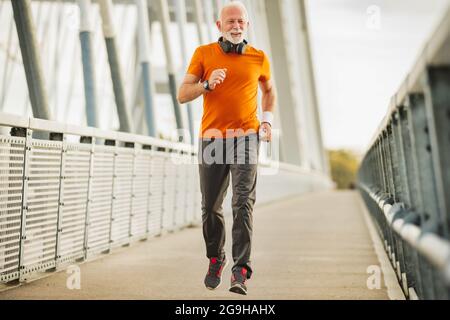 Sportlicher alter Mann Laufen macht Übungen Lebensqualität Stockfoto