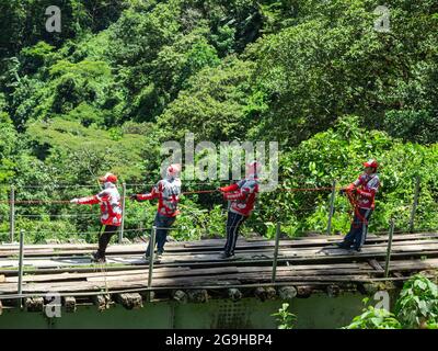 Amaga, Antioquia, Kolumbien - Juli 18 2021: Junge Kolumbianer ziehen am Seil, um den Bungee Jumper auf den Old Train Tracks hochzuziehen Stockfoto