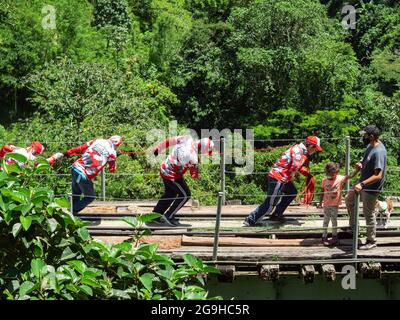 Amaga, Antioquia, Kolumbien - Juli 18 2021: Junge Kolumbianer ziehen am Seil, um den Bungee Jumper auf den Old Train Tracks hochzuziehen Stockfoto
