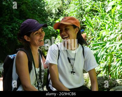 Amada, Antioquia, Kolumbien - Juli 18 2021: Ein Paar junger hispanischer Frauen, die mitten in der Natur lachen Stockfoto