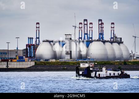 Hamburg, 22. Juli 2021: Fermenter einer Kläranlage des Hamburger Wasserwerks an der Elbe mit einer Fähre im Vordergrund auf der riv Stockfoto