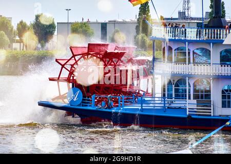 Hamburg, 22. Juli 2021: Schaufelrad auf dem Heck der Louisianna Queen, einem Ausflugsschiff, mit Lenticulars und Bokeh gegen die Sonne Stockfoto