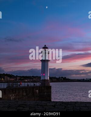 Newhaven Harbour Lighthouse mit Halbmond in farbenprächtigem rosa Nachthimmel, Edinburgh, Schottland, Großbritannien Stockfoto