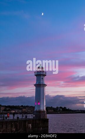 Newhaven Harbour Lighthouse mit Halbmond in farbenprächtigem rosa Nachthimmel, Edinburgh, Schottland, Großbritannien Stockfoto