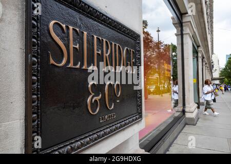 London, Großbritannien. 26. Juli 2021. Schilder an der Außenseite des Flaggschiff-Kaufhauses Selfridge in der Oxford Street. Die Kaufhauskette wurde von ihren Besitzern, der Familie Weston, zum Verkauf angeboten. Die Berater der Credit Suisse führen den Verkauf an und hoffen, bis Ende des Jahres einen Deal abzuschließen, der sich auf bis zu 4 Mrd. £belaufen könnte, was dem Bericht zufolge eher das Immobilienportfolio als das zugrunde liegende Geschäft widerspiegelt, das während der Coronavirus-Pandemie zu kämpfen hatte. Kredit: Stephen Chung / Alamy Live Nachrichten Stockfoto