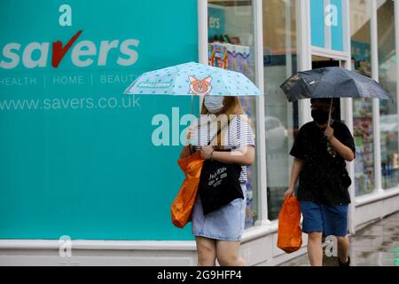 London, Großbritannien. Juli 2021. In London, nach der jüngsten Hitzewelle, schützen sich die Menschen vor Regen unter Regenschirmen. Kredit: SOPA Images Limited/Alamy Live Nachrichten Stockfoto