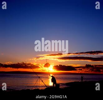 Fischer und Sonnenuntergang, Bristol Channel, Barry Island, South Wales. Stockfoto