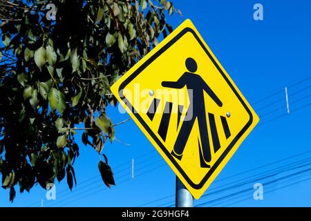 Fußgängerüberweg - gelbes Verkehrszeichen, das den Fußgängerüberweg signalisiert Stockfoto