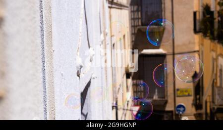 Seifenblasen fliegen vom Balkon in den Himmel. Spiel, Freiheit, Konzept Stockfoto