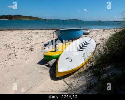 Boote und Paddeltafeln am Strand - Church Quay Beach, Bryher, Isles of Scilly, Cornwall, England, VEREINIGTES KÖNIGREICH. Stockfoto