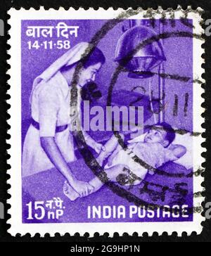 INDIEN - UM 1958: Eine in Indien gedruckte Briefmarke zeigt Krankenschwester und Kind, Kindertag, um 1958 Stockfoto