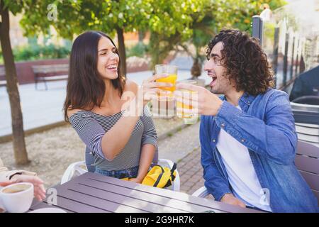 Ein paar Freunde toasten, während sie einen Drink mit ihrem Multiethnische Gruppe von Freunden Stockfoto