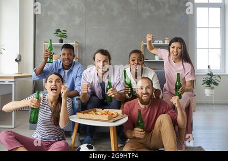 Eine Gruppe emotionaler und aktiver multirassischer Freunde, die sich zu Hause ein Fußballspiel im Fernsehen ansehen. Stockfoto