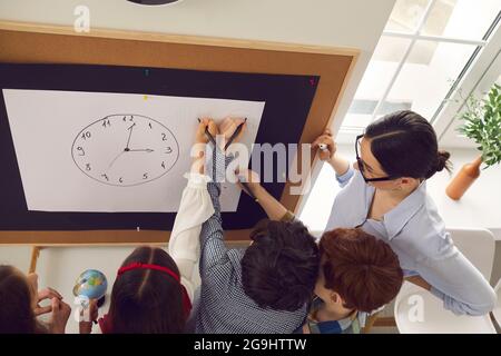 Overhead Aufnahme des Lehrers Schüler Uhr neben der Tafel stehen Stockfoto