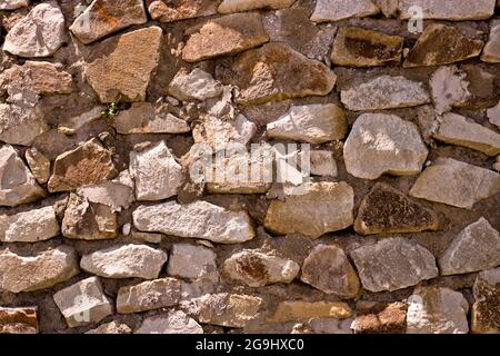 Grobes Mauerwerk mit Zement. Wandstruktur aus Stein. Rauer Hintergrund. Stockfoto