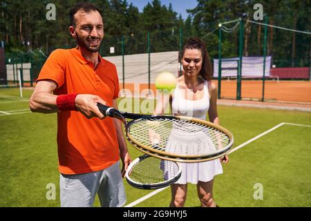 Anfängerspielerin lernt Tennis zu spielen Stockfoto