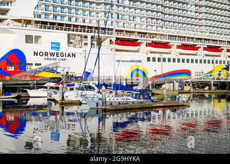 Seattle - 25. Juli 2021; Norwegian Cruise Line Schiff Norwegian Encore, das am Seattle Pier 66 eine farbenfrohe Reflexion auf das Wasser setzt Stockfoto