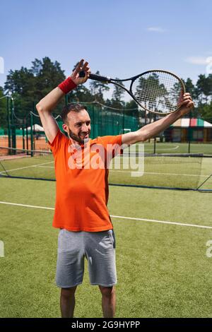 Ein professioneller Tennisspieler, der vor dem Spiel eine Aufwärmübung macht Stockfoto