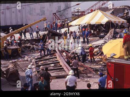 Brownsville Texas USA, Juli 8,1988: Freiwillige Helfer kämmen die Trümmer des Amigo-Ladens in der Innenstadt von Brownsville. Starke Regenfälle verursachten den Einsturz des Gebäudes und töteten 14 Menschen. Die Ingenieure stellten fest, dass eine defekte Konstruktion an einem Anbau im dritten Stock die Ursache für den Einsturz war. ©Bob Daemmrich Stockfoto