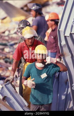 Brownsville Texas USA, Juli 8,1988: Freiwillige Helfer kämmen die Trümmer des Amigo-Ladens in der Innenstadt von Brownsville. Starke Regenfälle verursachten den Einsturz des Gebäudes und töteten 14 Menschen. Die Ingenieure stellten fest, dass eine defekte Konstruktion an einem Anbau im dritten Stock die Ursache für den Einsturz war. ©Bob Daemmrich Stockfoto