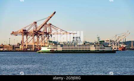 Seattle - 25. Juli 2021; Washington State Ferry Chimacum, das Frachtkrane passiert, wenn es sich dem Hafengebiet von Seattle nähert Stockfoto