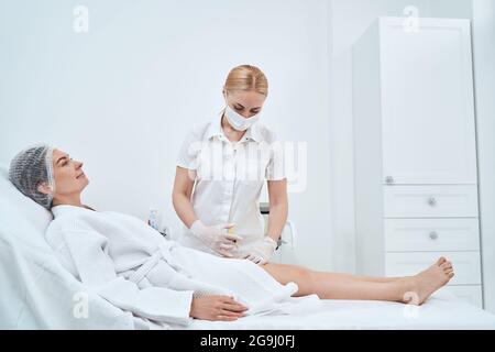 Zufrieden weibliche Person tun Schönheit Verfahren im Salon Stockfoto