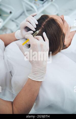 Nahaufnahme von Kosmetologen tun Haar Verfahren Stockfoto