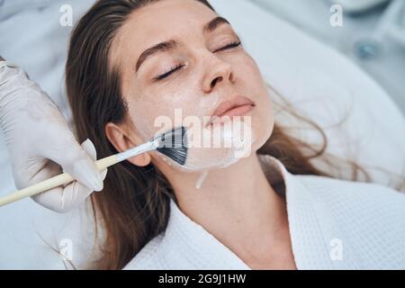 Porträt einer glücklichen Frau, die professionelle Maske macht Stockfoto