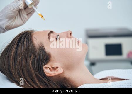 Nachdenkliche weibliche Person tut professionelle Schönheit Verfahren Stockfoto