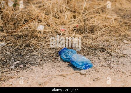 Zerknitterte Plastikflasche auf dem Feld, Umweltverschmutzung Stockfoto