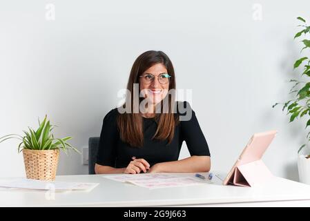 Porträt einer Illustratorin an ihrem Schreibtisch während der Telearbeit Stockfoto