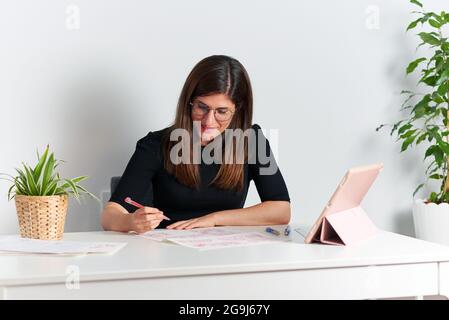 Illustrator Woman zeichnet Skizzen, die auf ihrem Schreibtisch sitzen Stockfoto