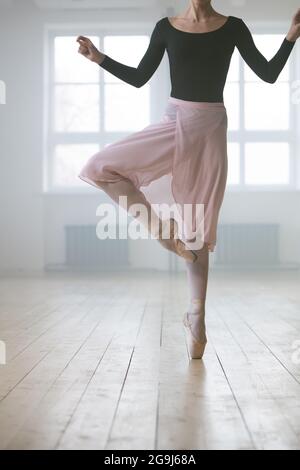 Nahaufnahme der Frau in Tutu-Kleid und in spitzenschuhen Auf einem Bein stehen und Ballett im Studio üben Stockfoto