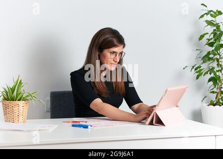 Porträt einer Illustratorin an ihrem Schreibtisch während der Telearbeit Stockfoto