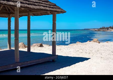 Wunderschöne Aussicht auf die Mittelmeerküste mit Birkenwasser, weißem Sandstrand und Bungalows am Ufer Stockfoto