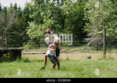 Kanada, Ontario, Kingston, Boys (8-9, 14-15) spielen im Freien kämpfen Stockfoto