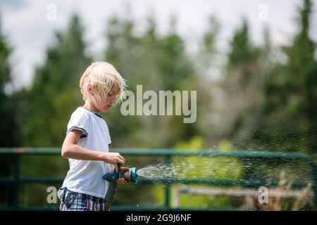 Kanada, Ontario, Kingston, Boy (8-9) mit Wasserschlauch Stockfoto