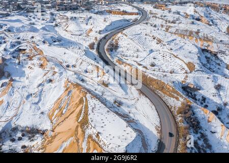 Türkei, Kappadokien, Luftaufnahme einer kurvenreichen Straße in felsiger Landschaft im Winter Stockfoto