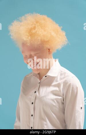 Studioporträt einer lächelnden Albino-Frau im weißen Hemd Stockfoto