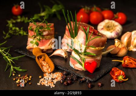 Frisches rohes Schweinefilet mit Speck auf Schiefertafel. Fleisch bereit zum Grill. Diät-Essen. Stockfoto