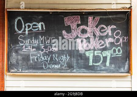 Colfax, Washington, USA. 22.Mai 2021. Kreidetafel Schild Werbung Restaurant Stunden und Joker Poker. Stockfoto