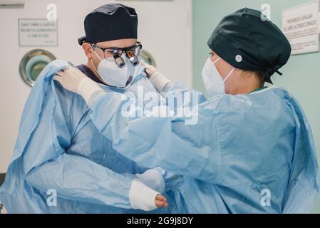 Arzt Vorbereitung für die chirurgische Operation im modernen Krankenhaus - Fokus auf männlichen Chirurgen Gesicht Stockfoto