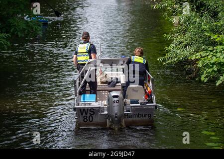 Hamburg, Deutschland. Juli 2021. Zwei Wasserpolizisten fahren mit ihrem Motorboot über den Mühlenkamp-Kanal. An heißen Sommertagen wird es auf der Alster voll - vor allem in den Kanälen. Gefahren für Freizeitkapitäne und die Natur sind die Folge. Quelle: Jonas Walzberg/dpa/Alamy Live News Stockfoto