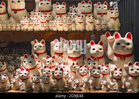 tokio, japan - juli 25 2021: Dutzende von Kawaii japanischen Manekineko Katze Glücksbringer Skulpturen, die die berühmte winkende Katze von Buddhis angeboten darstellen Stockfoto