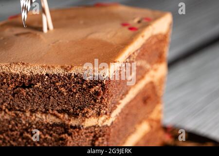 Stück eines braunen Schokoladenkuchens, verziert mit Rennflaggen auf einer Geburtstagsfeier Stockfoto