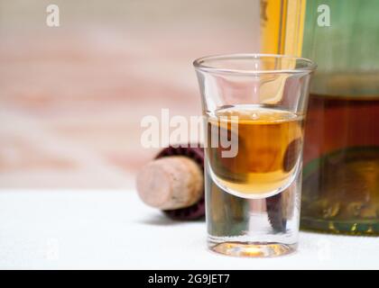 Glas Cognac. Ein Glas Spirituosen, Flasche und Korken auf dem Tisch Stockfoto